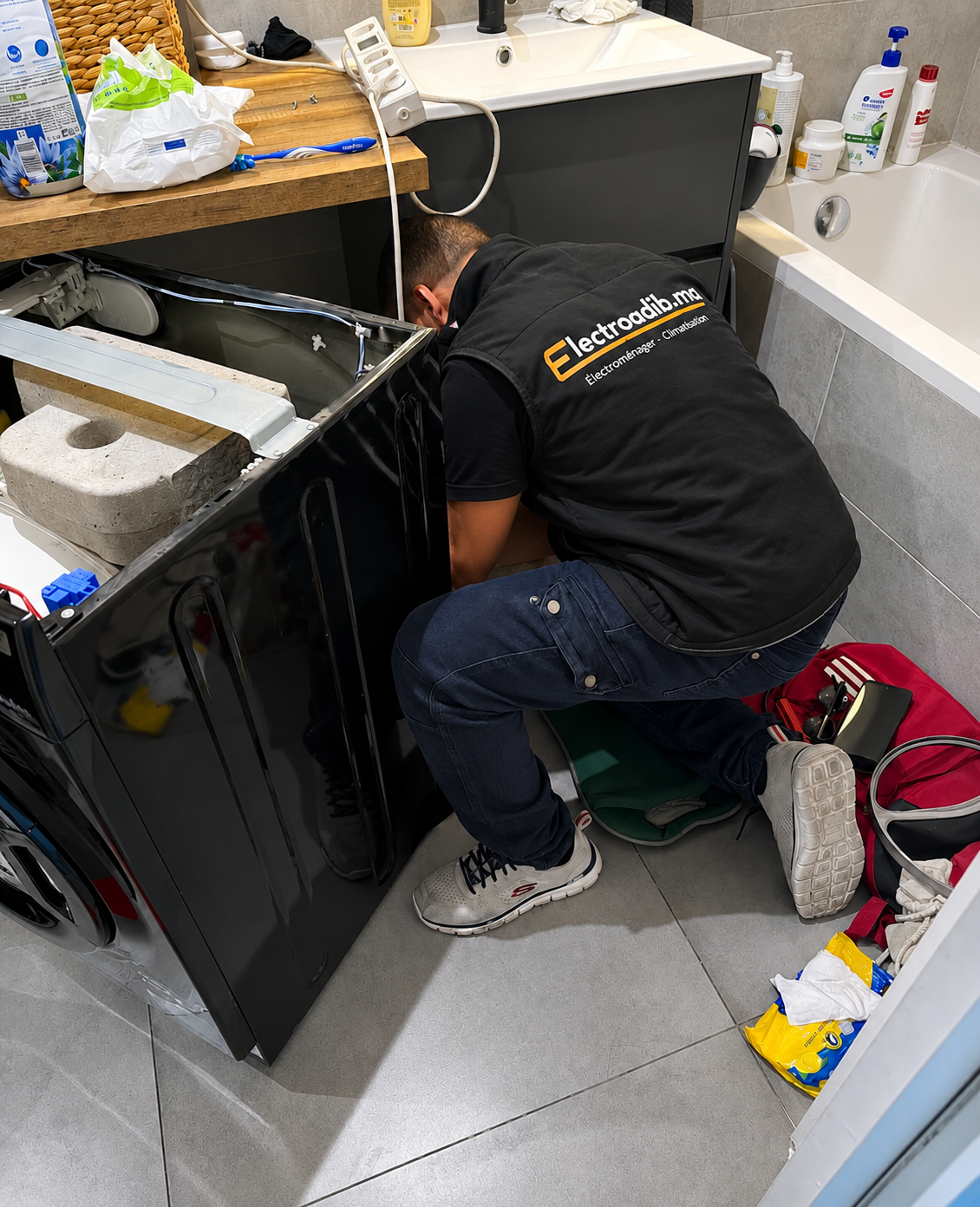 Technicien Electroadib qui répare un appareil électroménager