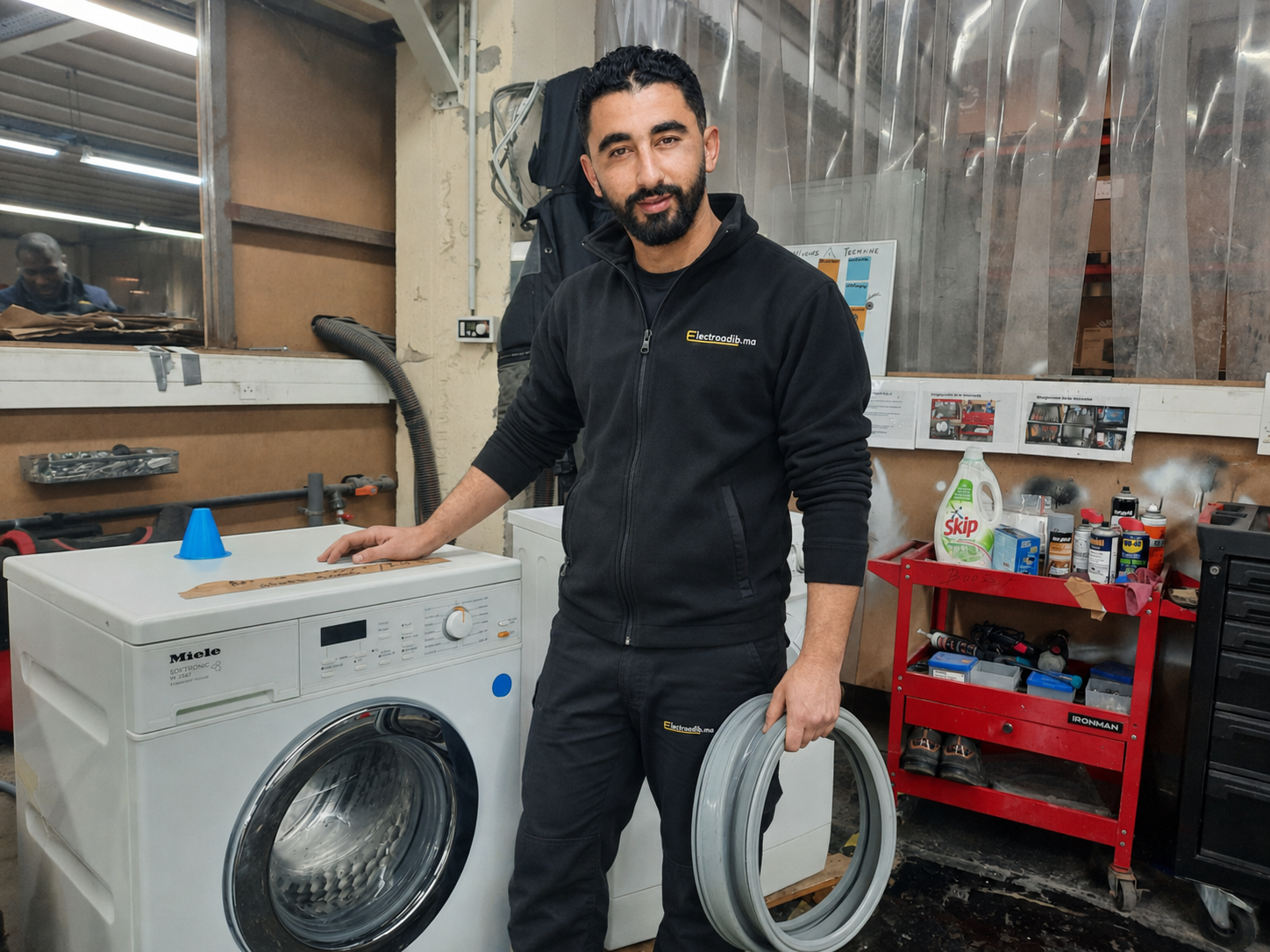 Technicien Electroadib avec un lave-linge Miele contrôlé en atelier